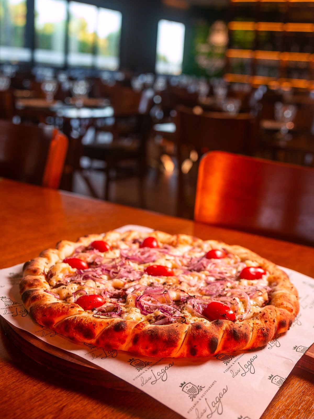 Pizza de tomatinho e cebola roxa na mesa do salão